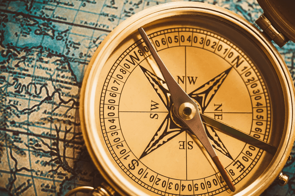 A vintage compass rests on an old map.
