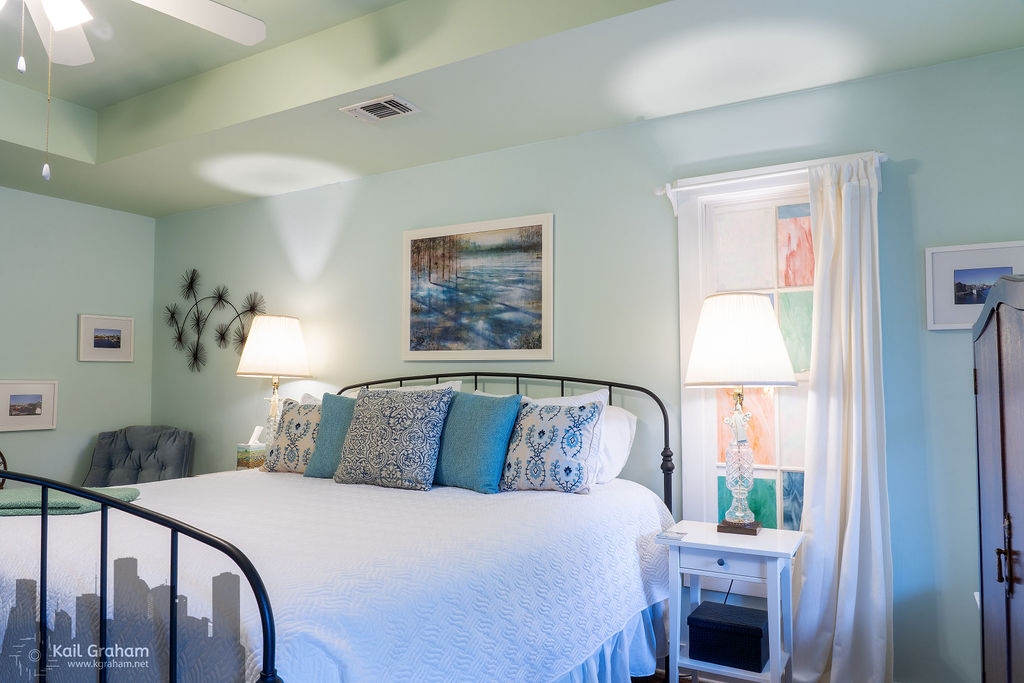 Different view of king-sized bed, padded rocking chair and wrought iron bistro set