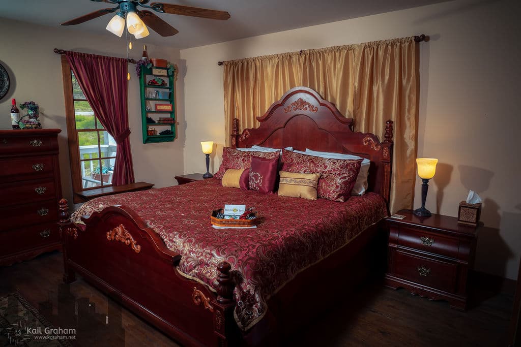 King-sized bed with paisley red and gold bedspread