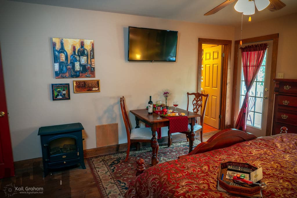 View showing fireplace, dining table, flat screen TV and doorway to bathroom