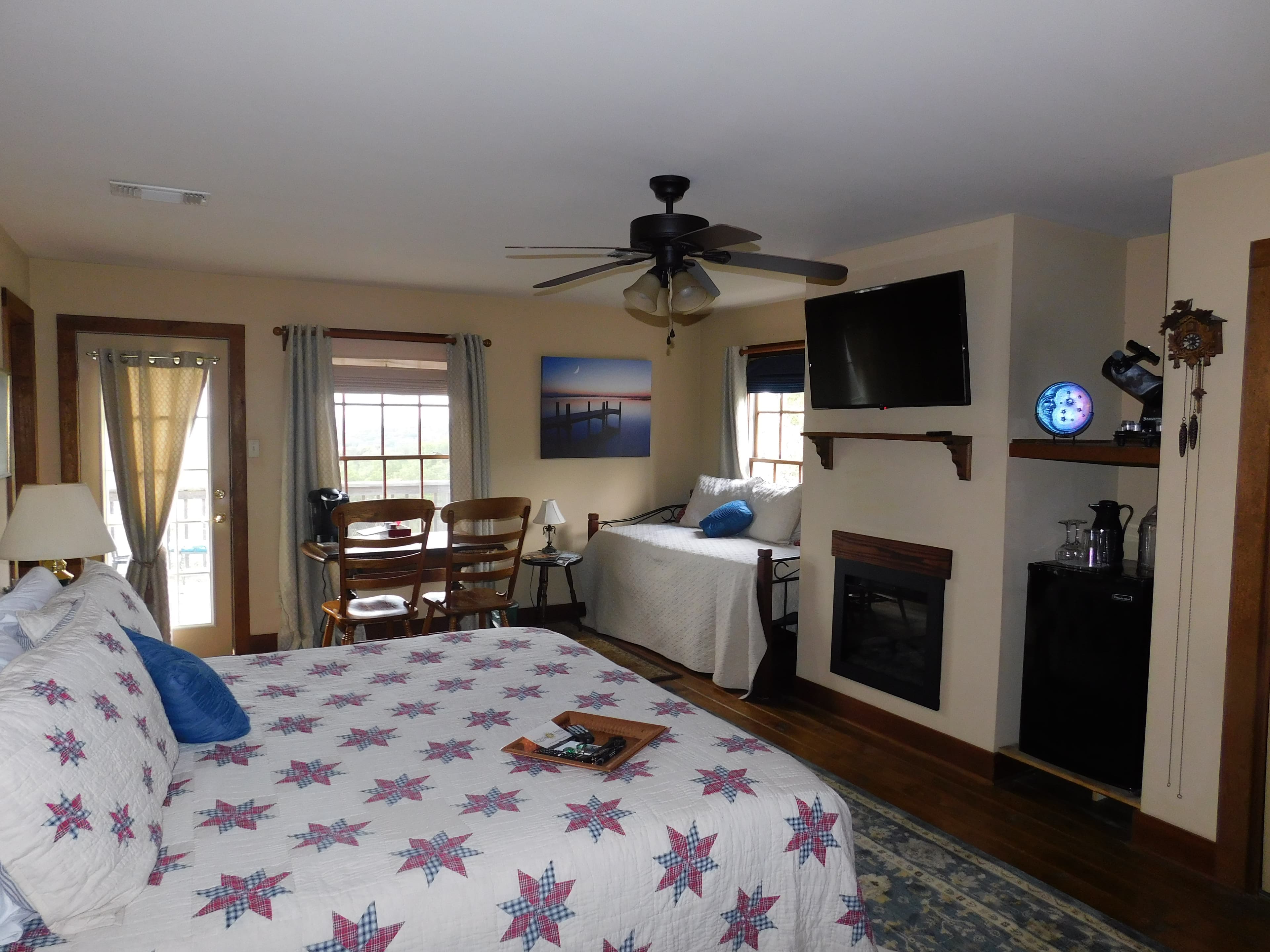 King-sized bed with daybed in corner, flat screen TV and mini refrigerator