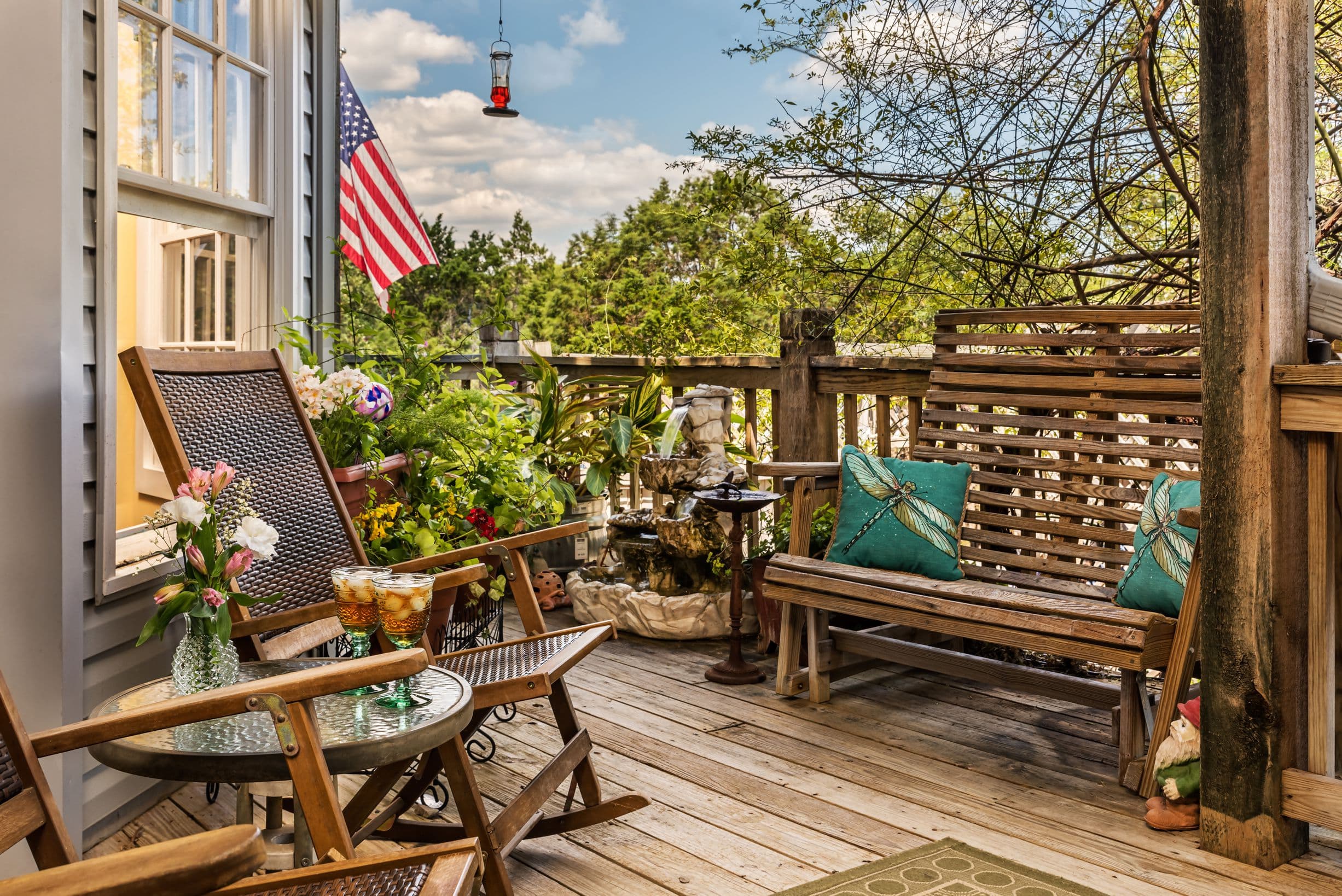 Cozy porch with rocking chairs, a bench, and a view of the outdoors.